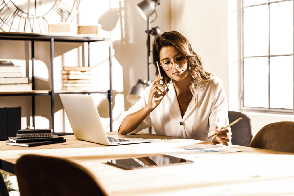 femme au téléphone pour représenter le pôle commercial d'i-media, agence digitale